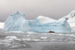 11B Zodiac Dwarfed By A Large Iceberg In Paradise Harbour On Quark Expeditions Antarctica Cruise.jpg